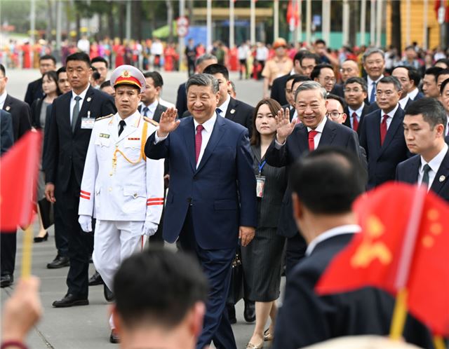 4月14日，中共中央总书记、国家主席习近平抵达河内对越南进行国事访问。当日下午，越共中央总书记苏林为习近平举行隆重欢迎仪式。这是欢迎仪式后，习近平和苏林一同步行前往越共中央驻地举行会谈时，向欢迎人群挥手致意。新华社记者 张领 摄